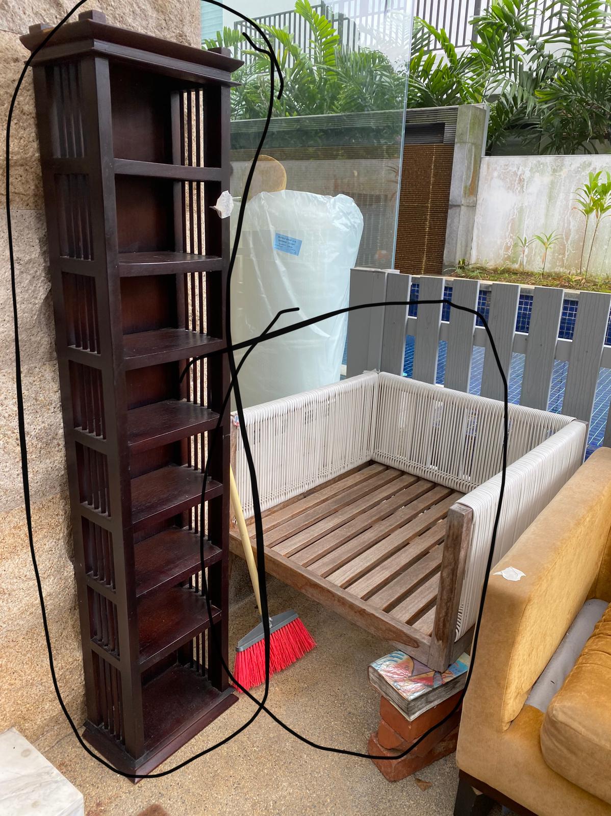 Dark wood bookshelf with white wicker side panels being removed from a residential home.